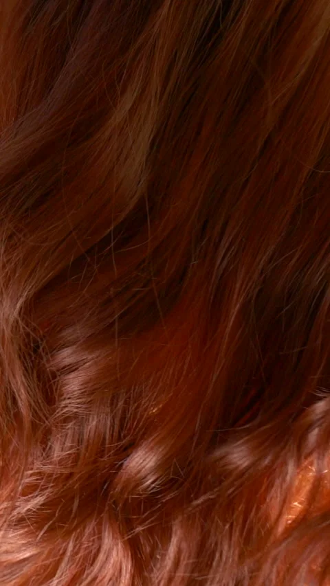 Vertical slow motion red curly hair texture, female brown long hair background Stock Footage 288940180