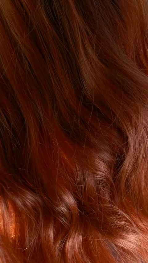 Vertical slow motion red curly hair texture, female brown long hair background Stock Footage 290486809