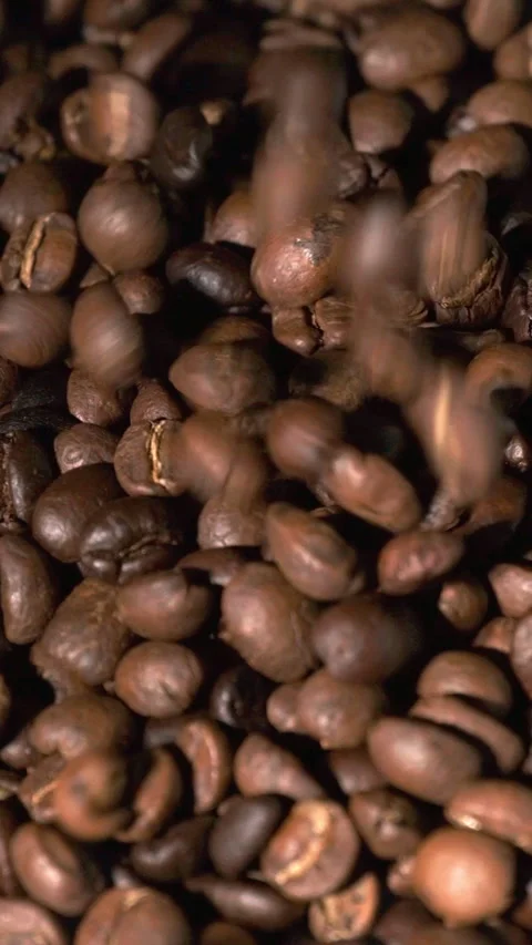 Vertical slow motion of roasted coffee beans falling. Stock Footage 244298046