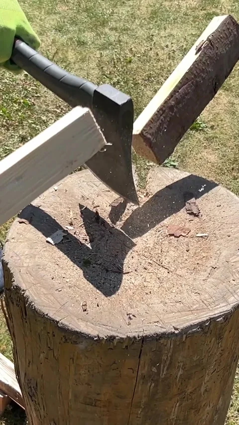 Vertical slow motion shot of axe splitting wood on chopping block, 1080p, slowmo Stock Footage 312524308