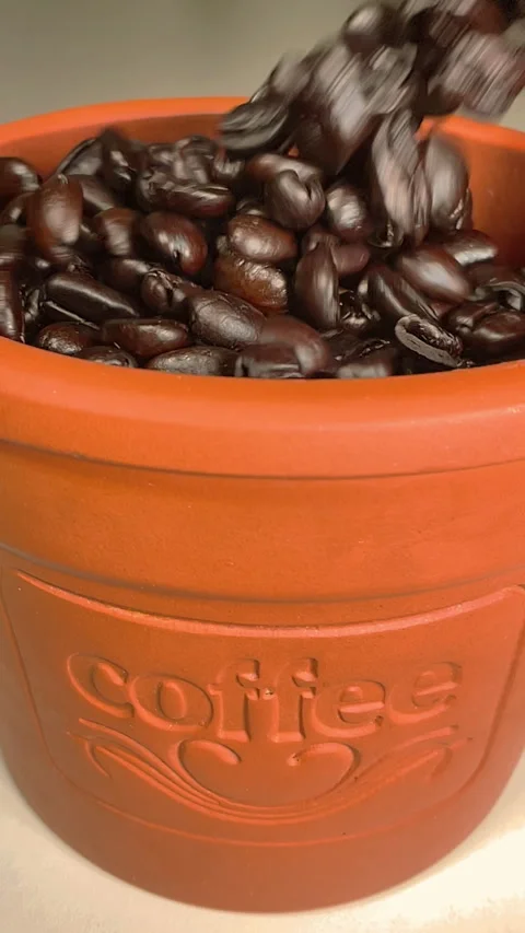 Vertical - Slow motion shot of roasted coffee beans pouring into a container. Stock Footage 289176683