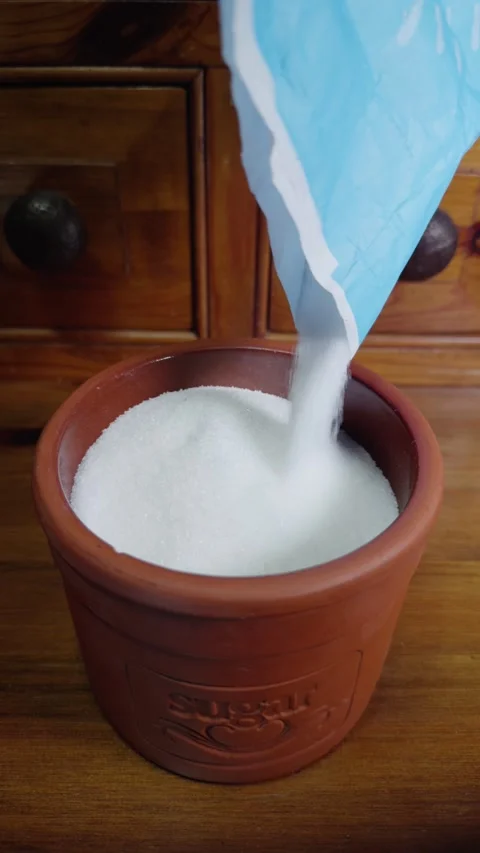 Vertical - Slow motion shot of white sugar granules pouring into a container. Stock Footage 292558408
