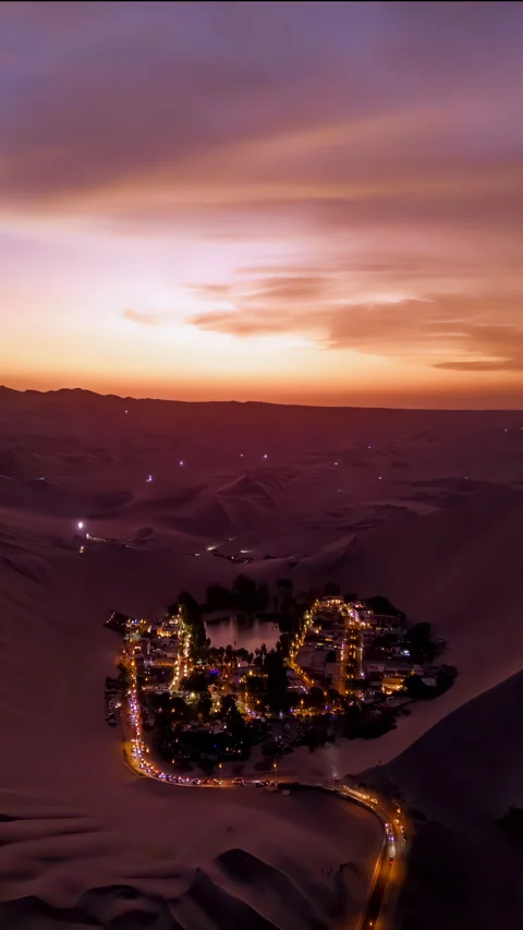 Vertical slow motion timelapse aerial view of Huacachina's oasis in Peru Stock Footage 306307387