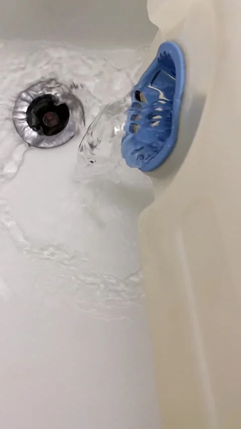 Vertical - Slow motion of a tumble dryer water tank emptying into a sink. Stock-Footage 289670663