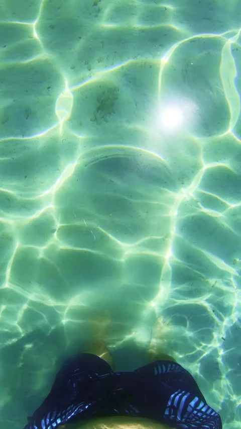 Vertical slow motion underwater view of man legs in crystal clear sea with c Stock Footage 337243841