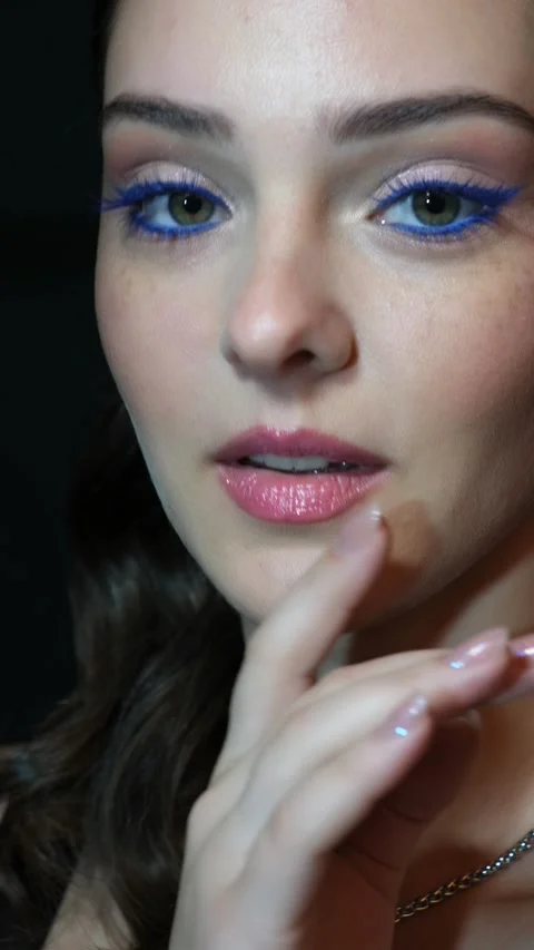 Vertical slow motion video of female face with blue eyes makeup. Stock Footage 343800436