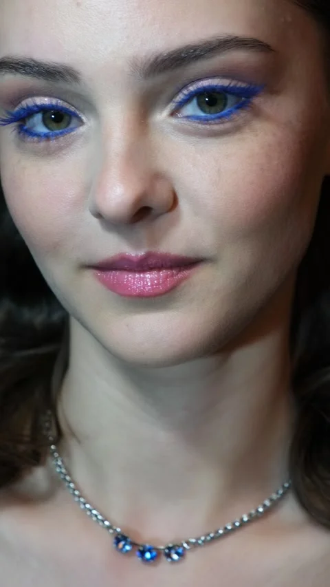 Vertical slow motion video of female face with blue eyes makeup. Stock Footage 343800508