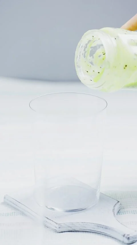 Vertical slow motion video of making green smoothie Stock Footage 230026624