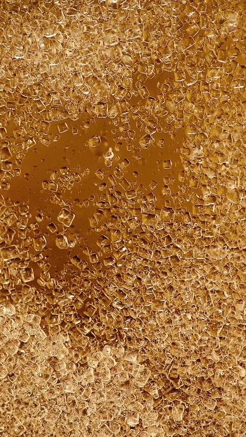 Vertical slow motion video of sugar crystals dissolving inside oil fluid Stock Footage 341825114