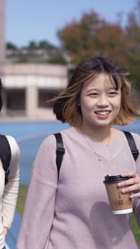 A vertical slow-motion video of two young Taiwanese female college students Stockbeeldmateriaal 266362844