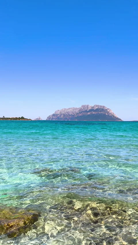 Vertical slow motion view of turquoise sea with Tavolara on the background Stock Footage 334236301