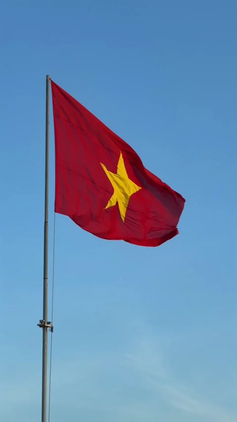 Vertical slow motion view of Vietnam flag waving smoothly in the wind, isolated Stock Footage 329372604
