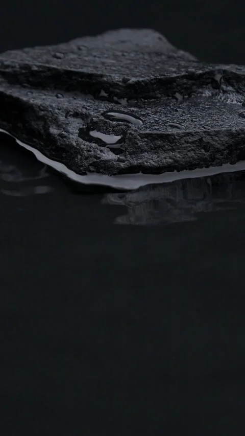 Vertical slow motion of water surface splashes, waves, ripples with black stone Stock Footage 257745983