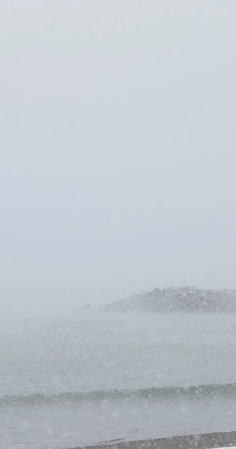 Vertical slow motion winter snow on Chigasaki beach in Japan Video stock 348205553