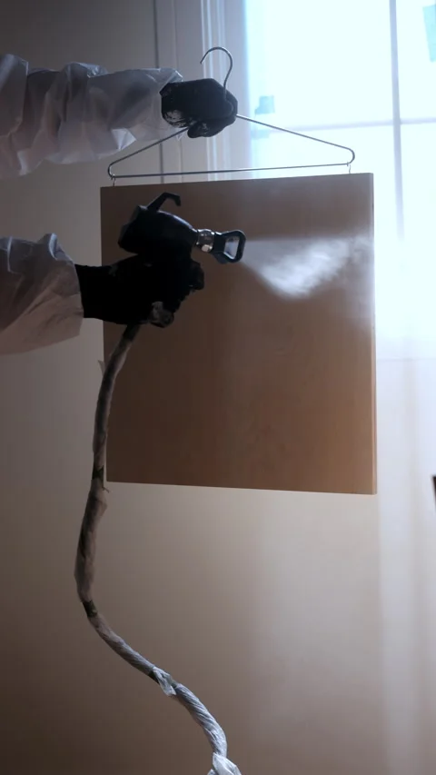 Vertical slow motion of Worker using a spray gun to apply paint or coating Stock Footage 334024151