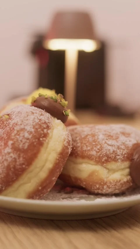 Vertical slow movement doughnut shot, chocolate pistachio topping, cozy cafe Stock Footage 321020053