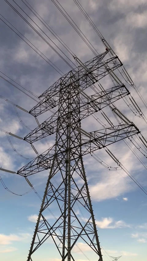 Vertical Slow Pull Back from High Voltage Power Transmission Tower Stock Footage 329894900