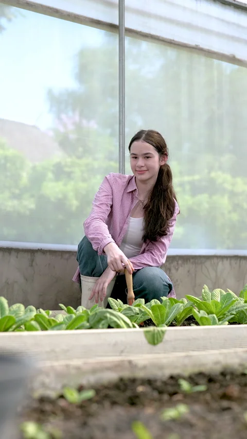 Vertical slowmotion closeup of multiracial female student in greenhouse smiling Stock Footage 320295189