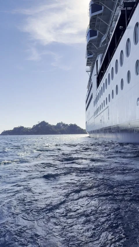 Vertical small boat rocking on waves beside cruise ship hull near Portofino Stock Footage 345961858