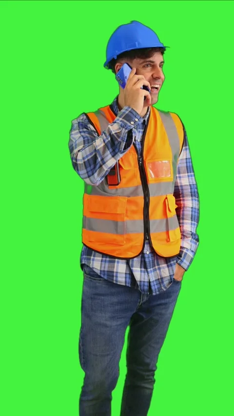Vertical Smiling construction worker chatting on his phone, wearing orange .. Stock Footage 287328063