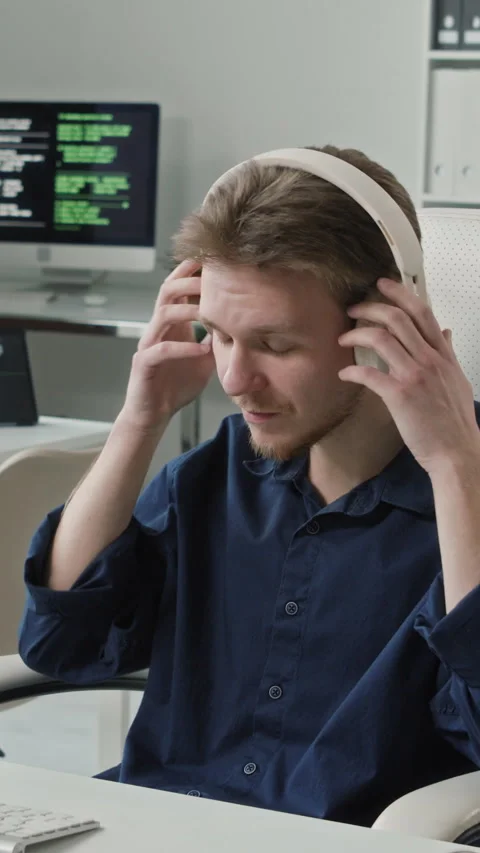 Vertical of Smiling Male IT Engineer Taking Headset off at Office Desk Stock Footage 330156683