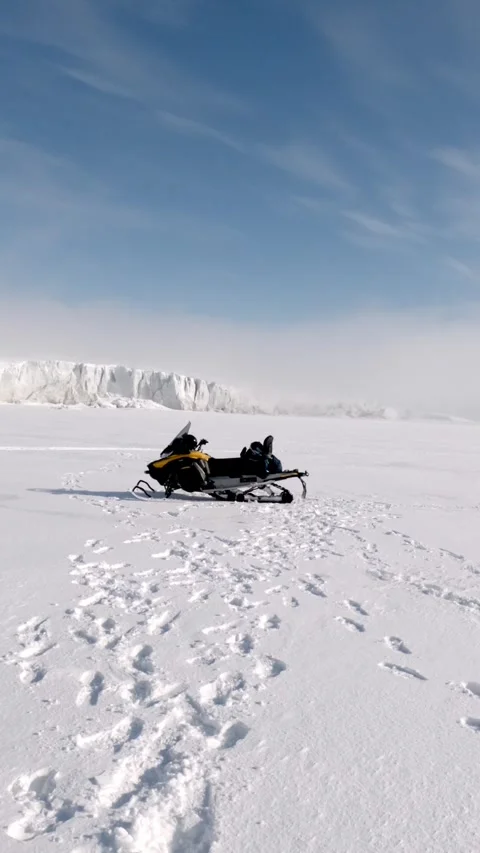 Vertical Snowmobile Expedition Scene in Front of Massive Svalbard Glacier Stock Footage 340036107
