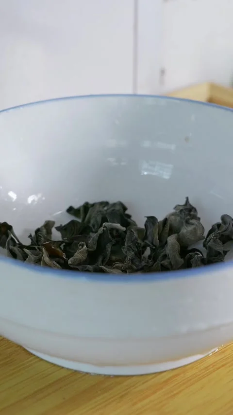 Vertical: Soaking dried wood ear mushrooms in cold clean water for rehydration. Stock Footage 341837399
