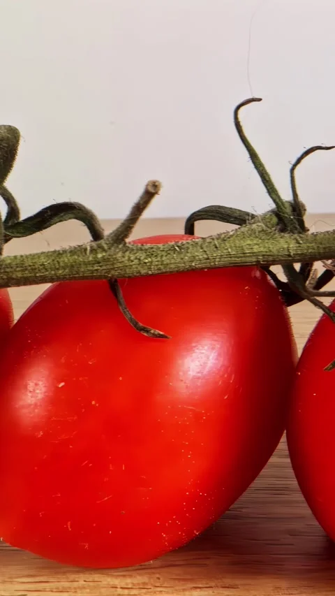 Vertical social ratio close-up of bright red tomatoes with a white background Stock Footage 336946025