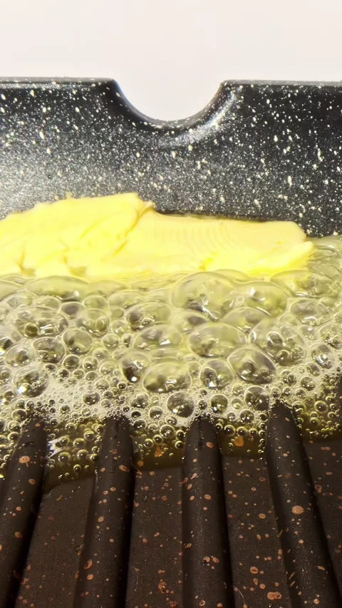 Vertical social ratio close-up video of butter cooking in a pan Stock Footage 336945733