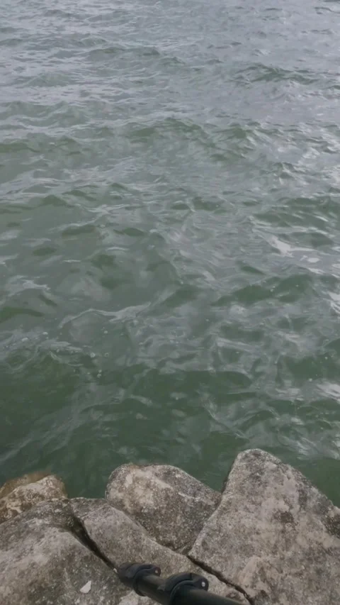 Vertical soft waves crashing against the rocks on the edge of the lake Stock Footage 307416830