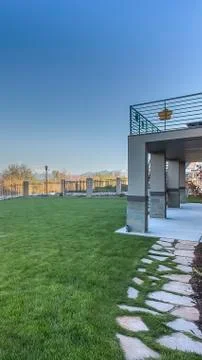 Vertical Spacious yard of home with view of lake and snowy mountain under blue Stock Photos