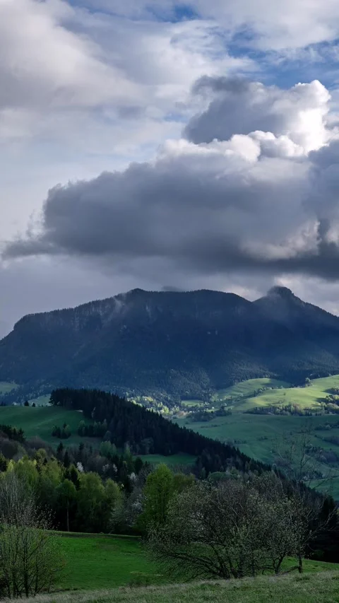 Vertical Spring storm clouds rolling over lush green mountain valley timelapse Stock-Footage 323383441