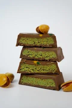 Vertical stack of chocolate bars with pistachio filling and whole nuts on top Stock Photos