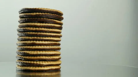 Vertical stack of chocolate cookies biscuits rotating slowly gray background Stock Footage 86399888