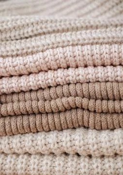 Vertical stack of colorful knitted items in a basket, showcasing cozy handm.. Stock Photos