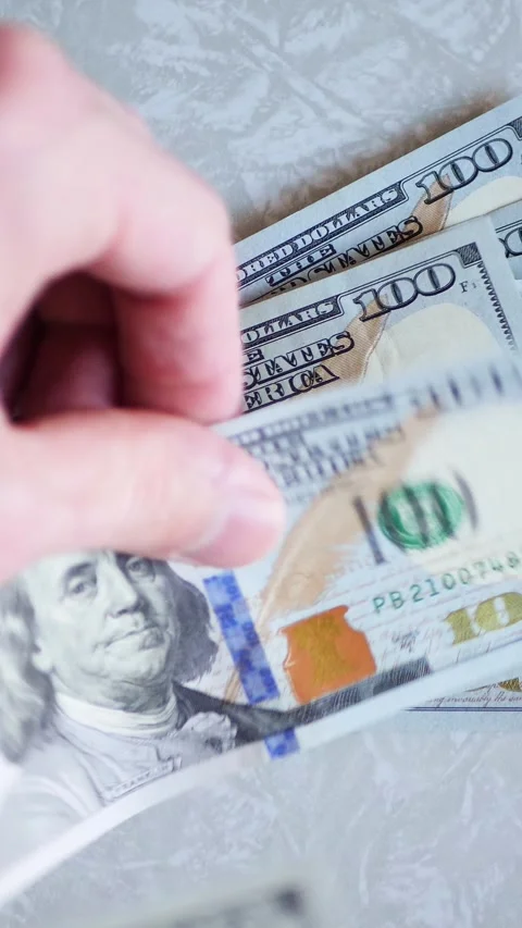 Vertical. A stack of crisp, dollar bills, held in capable hands. Stock Footage 304629517