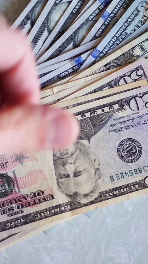 Vertical. A stack of crisp, dollar bills, held in capable hands. Stock Footage 304629561