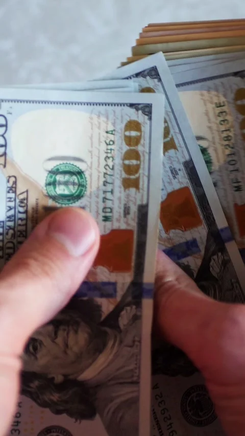 Vertical. A stack of crisp, dollar bills, held in capable hands. Stock Footage 304629734