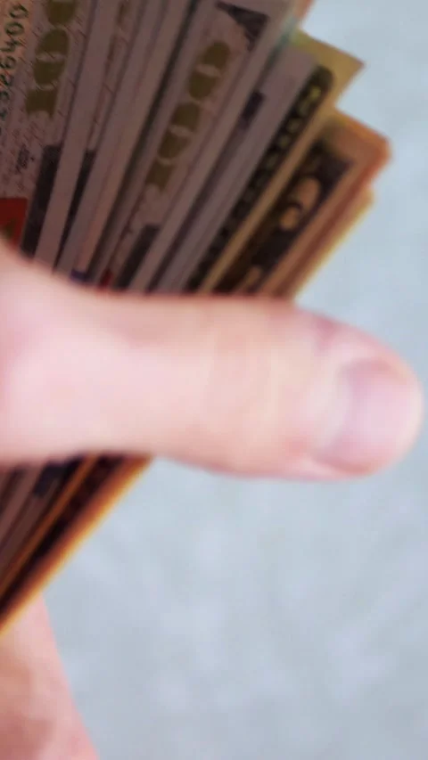 Vertical. A stack of crisp, dollar bills, held in capable hands. Stock Footage 304629911