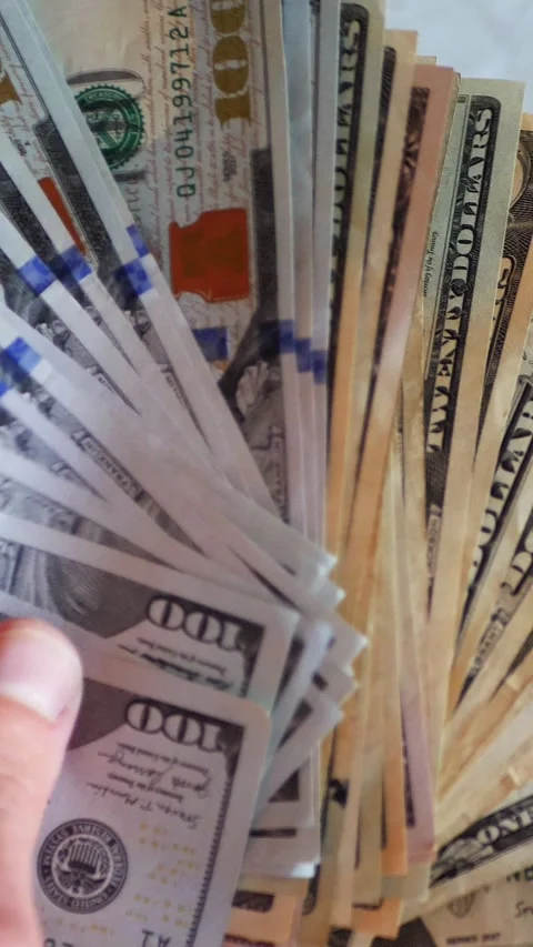 Vertical. A stack of crisp, dollar bills, held in capable hands. Stock Footage 304629952