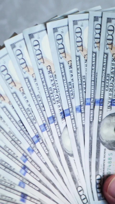 Vertical. A stack of crisp, dollar bills, held in capable hands. Stock Footage 304631758
