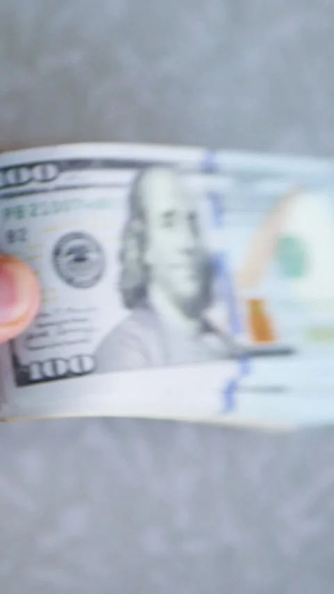 Vertical. A stack of crisp, dollar bills, held in capable hands. Stock Footage 304632528