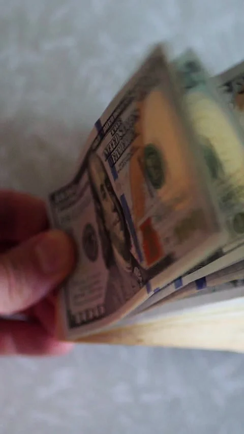 Vertical. A stack of crisp, dollar bills, held in capable hands. Stock Footage 304632586