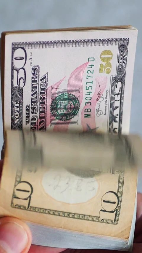 Vertical. A stack of crisp, dollar bills, held in capable hands. Stock Footage 304632621