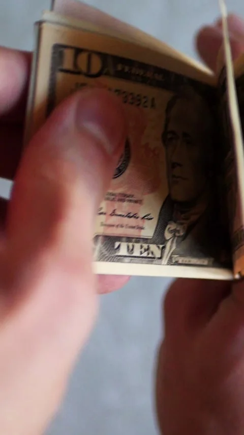 Vertical. A stack of crisp, dollar bills, held in capable hands. Stock Footage 304632709