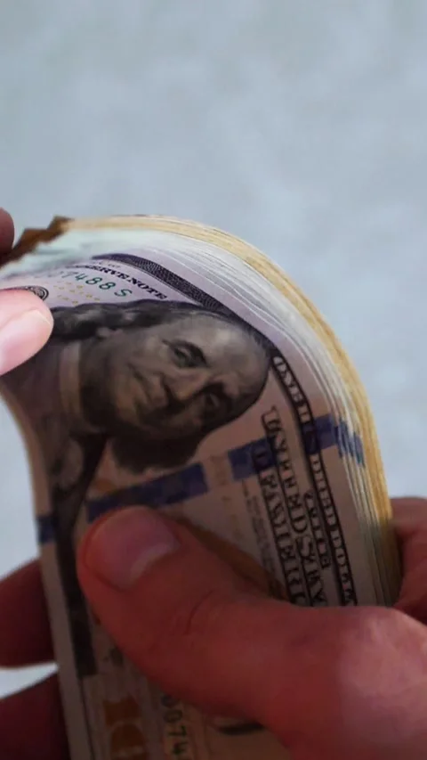 Vertical. A stack of crisp, dollar bills, held in capable hands. Stock Footage 304632800