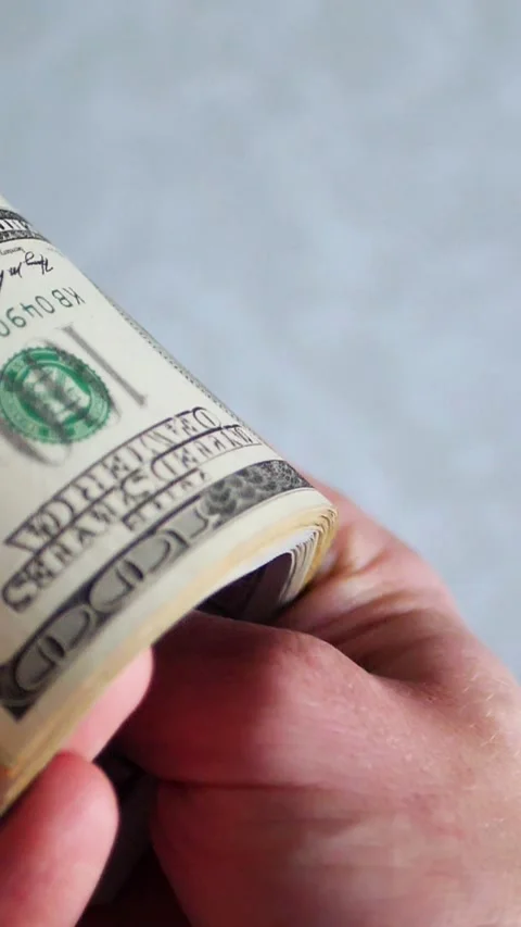 Vertical. A stack of crisp, dollar bills, held in capable hands. Stock Footage 304632813