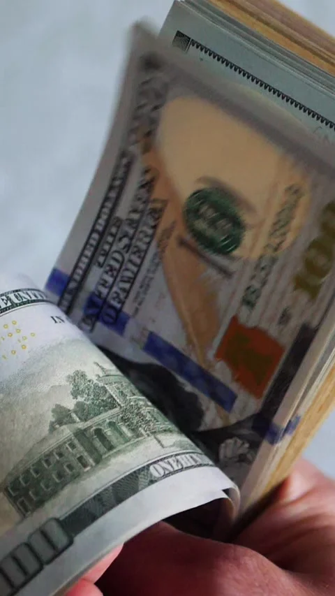 Vertical. A stack of crisp, dollar bills, held in capable hands. Stock Footage 304632815