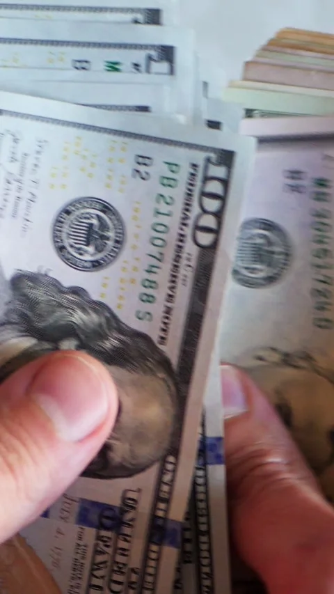 Vertical. A stack of crisp, dollar bills, held in capable hands. Stock Footage 304632854