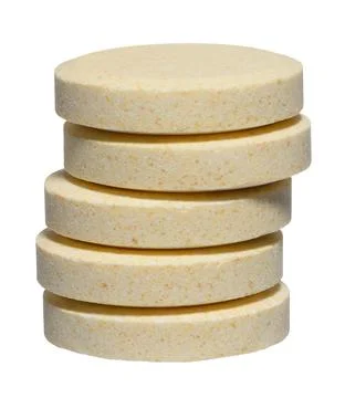 Vertical stack of large round pills of light yellow color, isolated backgroun Stockfoto's